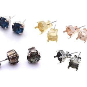 May include: Assortment of earring settings in silver, gold, and rose gold with a variety of gemstones, including blue, green, and clear.