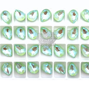 May include: A tray of 36 light green pearlescent teardrop-shaped rhinestones. The rhinestones are arranged in a grid pattern.