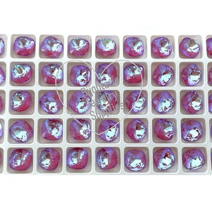 May include: A tray of 36 square-shaped iridescent glass rhinestones in a light pink color with a blue iridescent sheen.