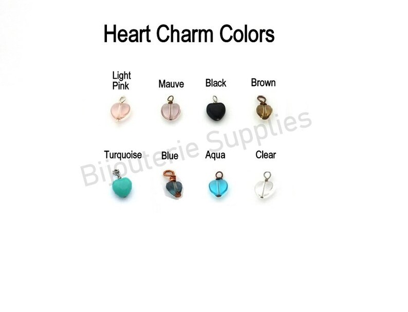 May include: Heart charm colors: light pink, mauve, black, brown, turquoise, blue, aqua, and clear. Each charm is a small heart-shaped bead with a loop for attaching to a necklace or bracelet.