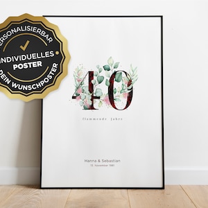 Può includere: Un poster bianco con cornice nera che presenta un'illustrazione ad acquerello del numero 40 decorato con foglie verdi e fiori rosa. Il testo "flammende Jahre" è sotto il numero. I nomi Hanna & Sebastian e la data 13. November 1981 sono in fondo al poster.