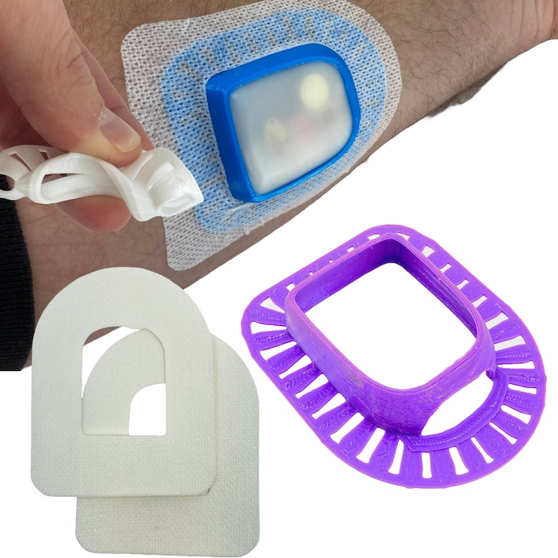 May include: Three 3D printed medical devices. A white, rectangular, adhesive patch with a blue, rectangular, clear plastic device on top. A purple, 3D printed, circular device with a square opening in the center. A white, 3D printed, rectangular device with a curved opening in the center.