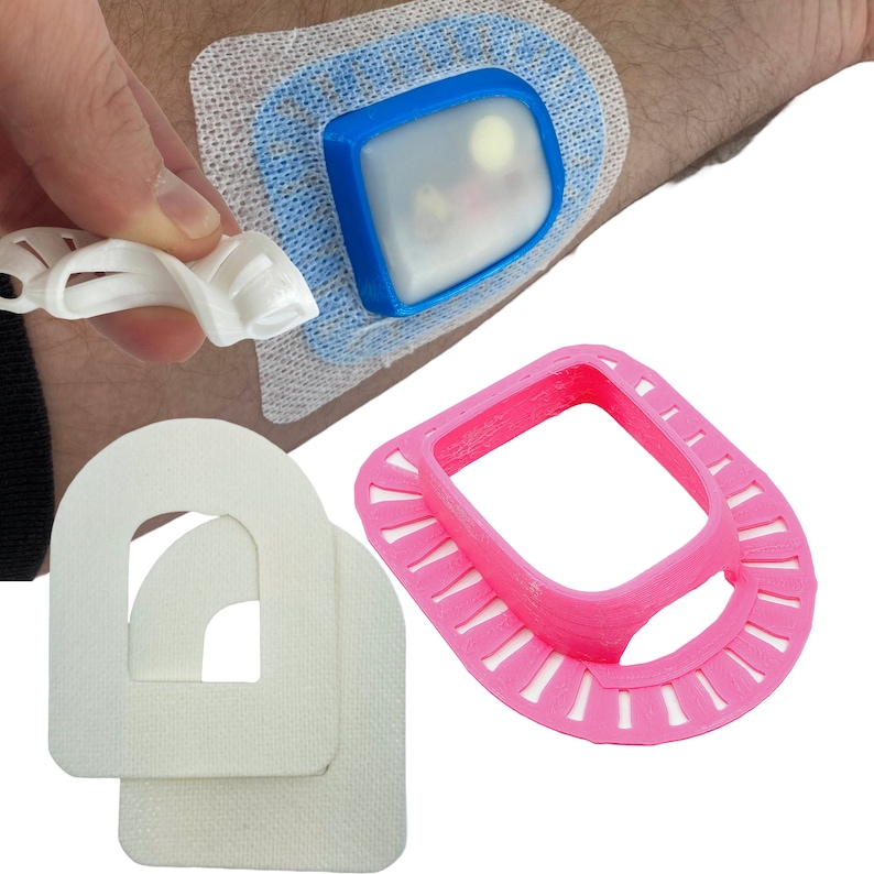 May include: Three 3D printed medical devices. One is a white, semi-circular, adhesive patch with a cut-out in the center. Another is a pink, circular, 3D printed device with a square cut-out in the center. The third is a blue and white device with a clear plastic window.
