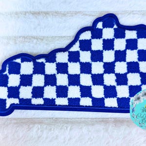 May include: A tufted rug shaped like the state of Kentucky featuring a blue and white checkered pattern. The rug has a thick blue border and a circular logo in the bottom right corner with the text White Oak Craft Boutique and a tree graphic.