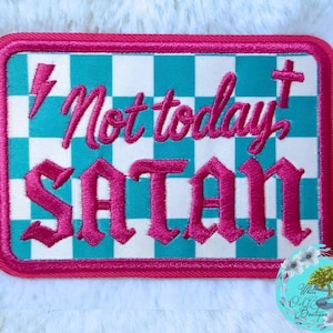 May include: A rectangular embroidered patch featuring a teal and white checkered background with a hot pink border. The text "Not today" is stitched in hot pink cursive, and the word "SATAN" is stitched in hot pink block lettering.