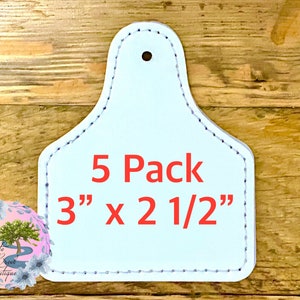 May include: A pack of five white leather tags with a hole at the top. The tags are 3 inches by 2 1/2 inches and have a stitched edge. The text "5 Pack 3" x 2 1/2" is printed in red on the tags.