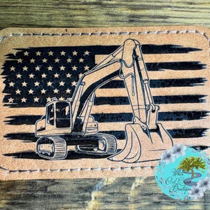 May include: A brown leather patch with a black and white American flag design and a black silhouette of an excavator.