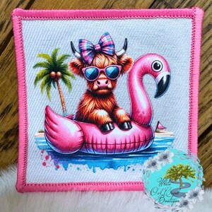 May include: A pink flamingo pool float with a brown and white Highland cow wearing sunglasses and a pink and blue bow sitting on top of it. The float is on a blue and white background with a palm tree in the background.