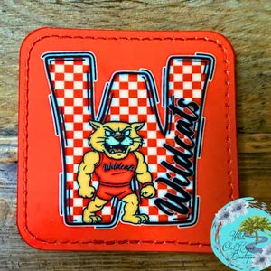 May include: Orange square patch with a cartoon wildcat mascot in a red uniform. The letter "W" is filled with a red and white checkered pattern, and the word "Wildcats" is written in black script.