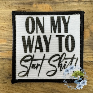 May include: White fabric patch with black text that reads "On My Way To Start Shit!"
