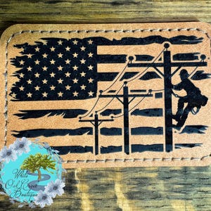 May include: A brown leather patch with a black silhouette of an electrician working on a power line in front of an American flag.
