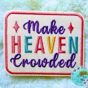 May include: A rectangular embroidered patch with a cream-colored background and a red border. The text "Make" is in purple script, "HEAVEN" is in multi-colored block letters, and "Crowded" is in purple script. Two small red four-pointed stars are included.