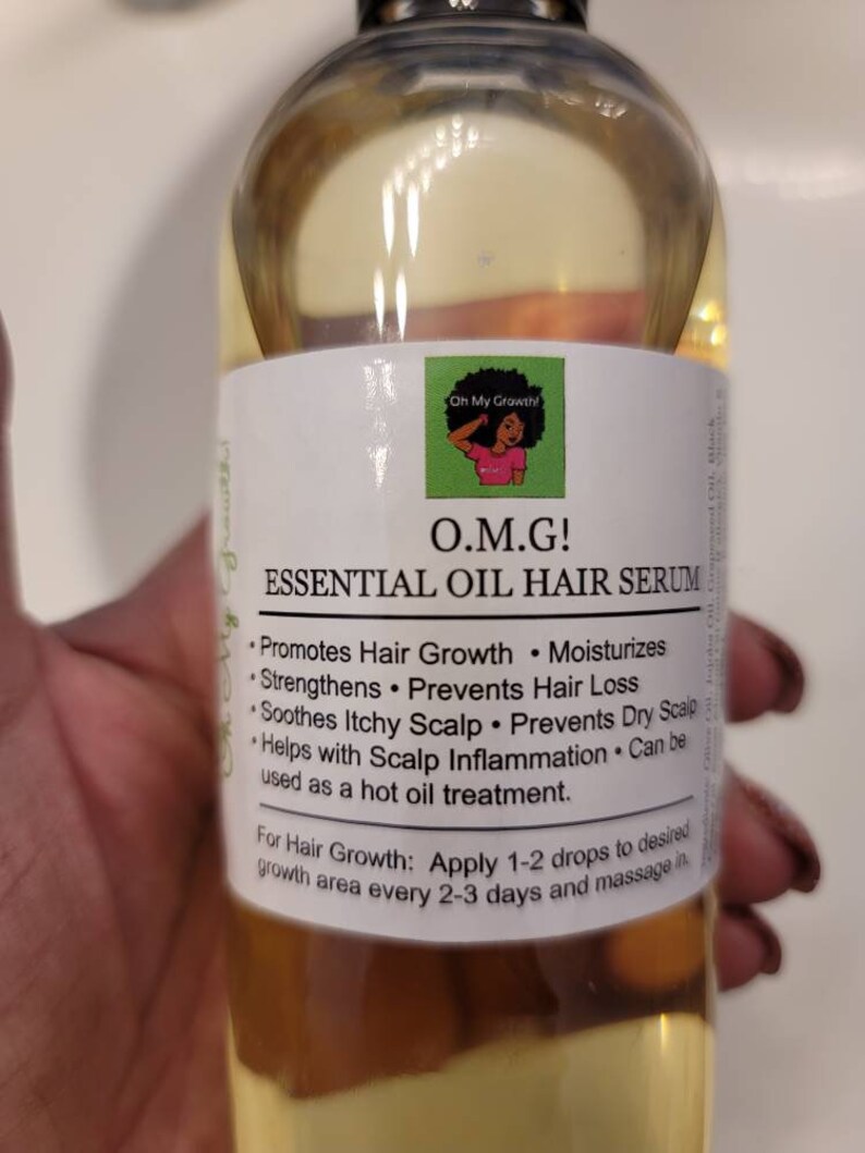 Puede incluir: Una botella de vidrio transparente con un l&iacute;quido amarillo en su interior. La botella tiene una etiqueta blanca con el texto "O.M.G! ESSENTIAL OIL HAIR SERUM" y una lista de beneficios, que incluyen promover el crecimiento del cabello, hidratar, fortalecer, prevenir la p&eacute;rdida de cabello, calmar el cuero cabelludo con picaz&oacute;n, prevenir el cuero cabelludo seco y ayudar con la inflamaci&oacute;n del cuero cabelludo. La etiqueta tambi&eacute;n indica que el suero se puede usar como un tratamiento de aceite caliente. La etiqueta indica aplicar 1-2 gotas en el &aacute;rea de crecimiento deseada cada 2-3 d&iacute;as y masajear.