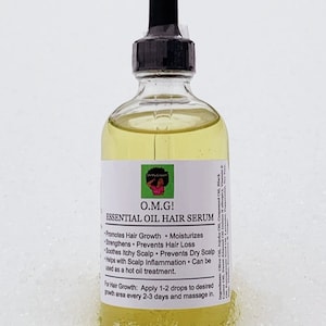 K&ouml;nnte beinhalten: Eine durchsichtige Glasflasche mit einem schwarzen Tropfer oben, gef&uuml;llt mit einer gelben Fl&uuml;ssigkeit. Das Flaschenetikett lautet "O.M.G! Essentielles &Ouml;l Haars&eacute;rum" und listet die Vorteile des Serums auf, darunter die F&ouml;rderung des Haarwachstums, die Befeuchtung, die St&auml;rkung, die Vorbeugung von Haarausfall, die Beruhigung von juckender Kopfhaut, die Vorbeugung von trockener Kopfhaut und die Hilfe bei Kopfhautentz&uuml;ndungen. Die Flasche steht auf einer wei&szlig;en Oberfl&auml;che.