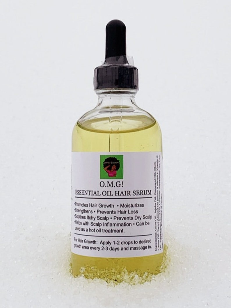 K&ouml;nnte beinhalten: Eine durchsichtige Glasflasche mit einem schwarzen Tropfer oben, gef&uuml;llt mit einer gelben Fl&uuml;ssigkeit. Das Flaschenetikett lautet "O.M.G! Essentielles &Ouml;l Haars&eacute;rum" und listet die Vorteile des Serums auf, darunter die F&ouml;rderung des Haarwachstums, die Befeuchtung, die St&auml;rkung, die Vorbeugung von Haarausfall, die Beruhigung von juckender Kopfhaut, die Vorbeugung von trockener Kopfhaut und die Hilfe bei Kopfhautentz&uuml;ndungen. Die Flasche steht auf einer wei&szlig;en Oberfl&auml;che.