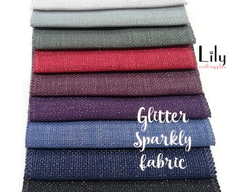 May include: A stack of 10 different colors of glitter fabric. The fabric is a mesh material with a sparkly finish. The text "Glitter Sparkly Fabric" is written on the fabric.