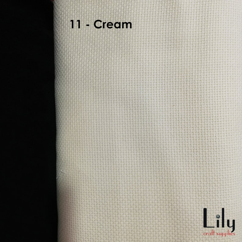 Peut inclure: Tissu Aida de couleur cr&egrave;me avec une texture tiss&eacute;e. Le tissu est &eacute;tiquet&eacute; "11 - Cr&egrave;me" et porte le texte "Lily craft supplies" dans le coin inf&eacute;rieur droit.