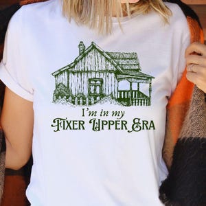 May include: White t-shirt with a green line drawing of a house and the text "I'm in my Fixer Upper Era".