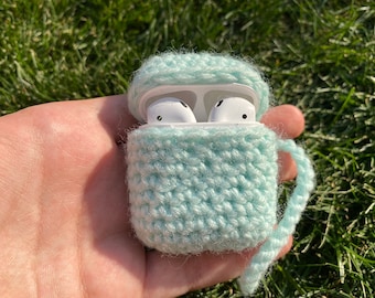 May include: A light blue crocheted case for wireless earbuds with a white cord.