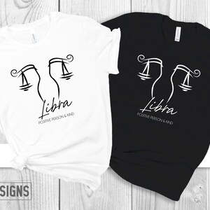 May include: Two t-shirts, one white and one black, with a Libra zodiac symbol and the text "Libra Positive Person & Kind".