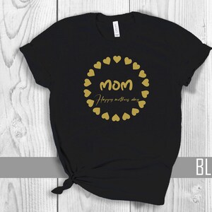 May include: Black t-shirt with a gold circle of hearts and the text "MOM Happy Mother's Day".