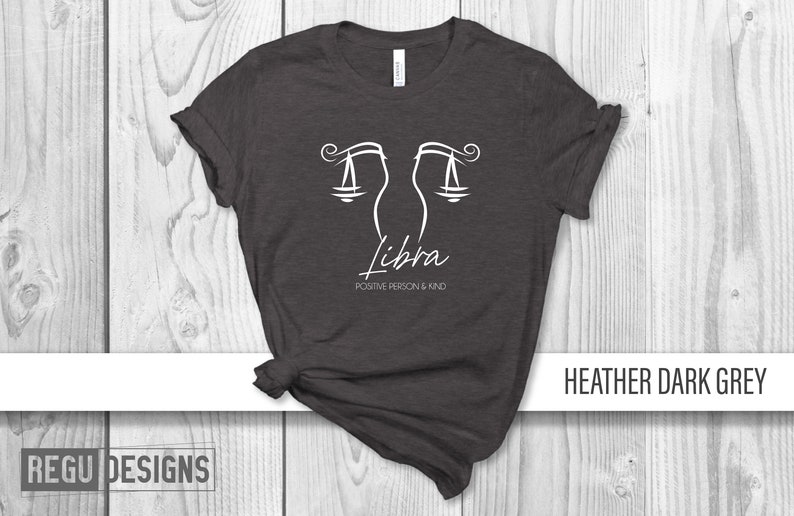 May include: Heather dark grey t-shirt with a white Libra zodiac symbol and the text "Positive Person & Kind".