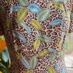 Puede incluir: Un vestido marr&oacute;n y blanco con estampado de leopardo y estampado floral verde y azul.