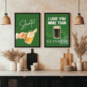 May include: Two framed green wall art prints. One says "Sl&aacute;inte!" with a hand holding a beer mug. The other says "I LOVE YOU MORE THAN GUINNESS" with a pint of Guinness. Both have black frames.