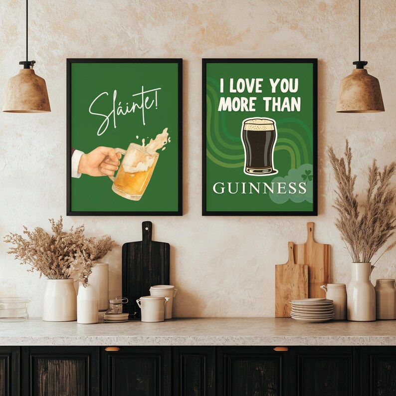 May include: Two framed green wall art prints. One says "Sl&aacute;inte!" with a hand holding a beer mug. The other says "I LOVE YOU MORE THAN GUINNESS" with a pint of Guinness. Both have black frames.