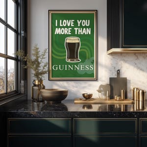 May include: A framed poster with the text "I LOVE YOU MORE THAN GUINNESS" on a green background. The poster features a graphic of a pint of Guinness stout. The frame is gold.