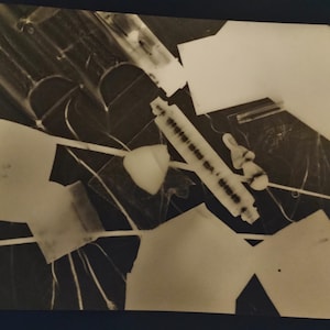 Puede incluir: Fotografía abstracta en blanco y negro con formas geométricas y un rodillo. La imagen tiene una estética de alto contraste, con varias formas y líneas que crean una composición dinámica. El rodillo es un elemento central.