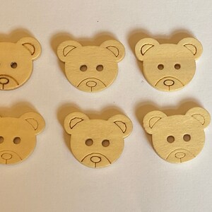 Pode incluir: Seis bot&otilde;es de madeira em forma de urso de cor castanho claro. Os bot&otilde;es t&ecirc;m dois pequenos furos para costurar.