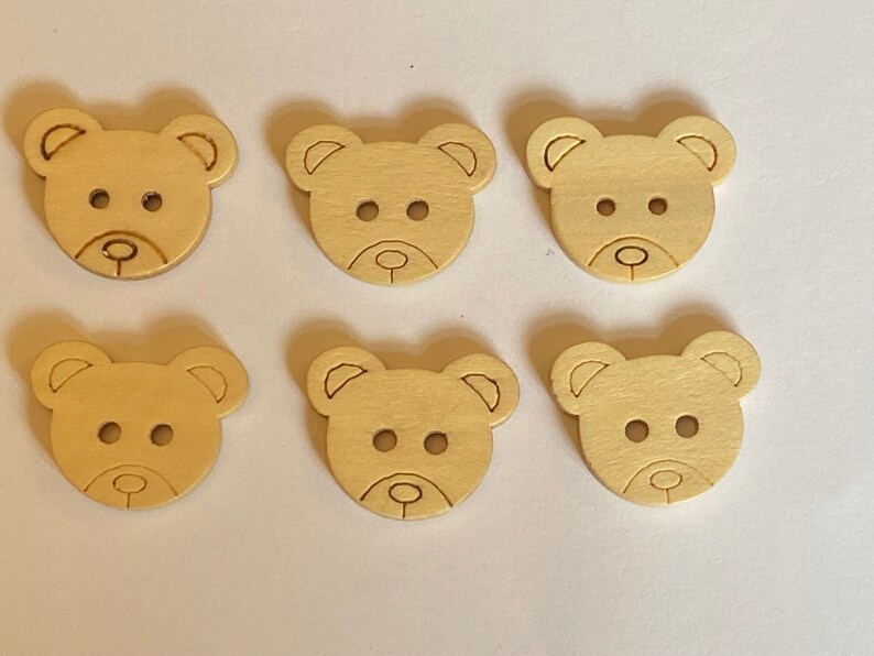 Pode incluir: Seis bot&otilde;es de madeira em forma de urso de cor castanho claro. Os bot&otilde;es t&ecirc;m dois pequenos furos para costurar.