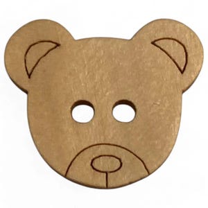 May include: A light brown wooden button shaped like a teddy bear's face. It features two eye holes and a mouth, with the ears outlined in a darker brown. Ideal for sewing or craft projects.