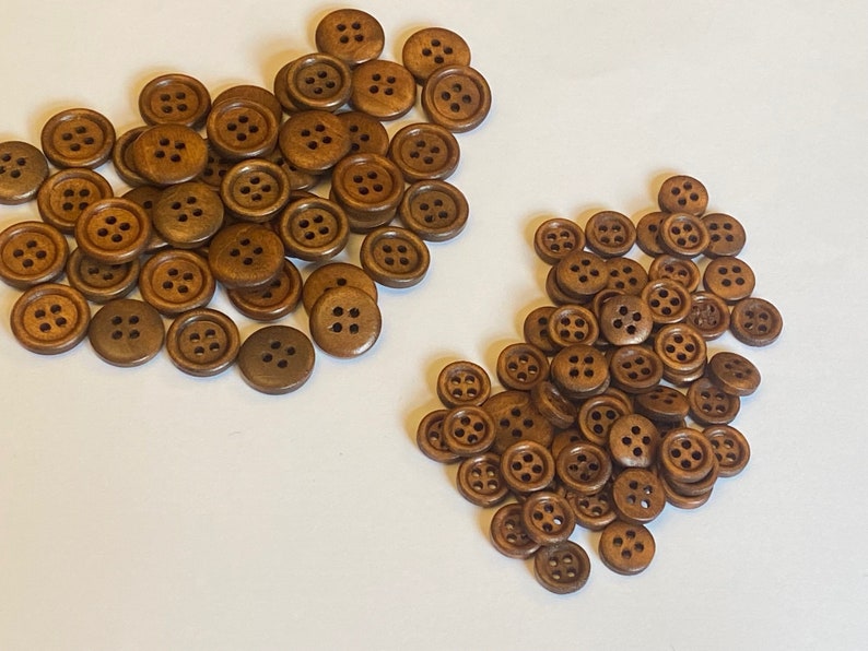 May include: A large pile of brown wooden buttons with four holes each. The buttons are arranged in a random pattern.
