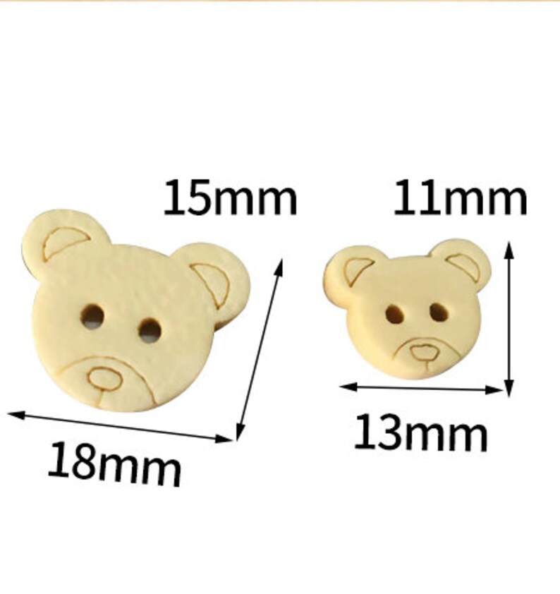 Pode incluir: Dois bot&otilde;es de madeira em forma de urso. O bot&atilde;o maior mede 18 mm de largura e 15 mm de altura. O bot&atilde;o menor mede 13 mm de largura e 11 mm de altura.