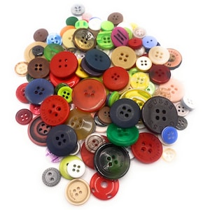 May include: A large collection of colourful buttons with various designs and logos, including "Since 1980", "La Chapelle", "Guess", and "London Dog".