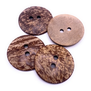 May include: Four brown coconut shell buttons with two holes each. The buttons have a natural, rustic look.
