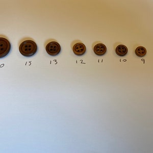 May include: A set of eight brown wooden buttons of varying sizes, labelled with numbers 9 through 20.