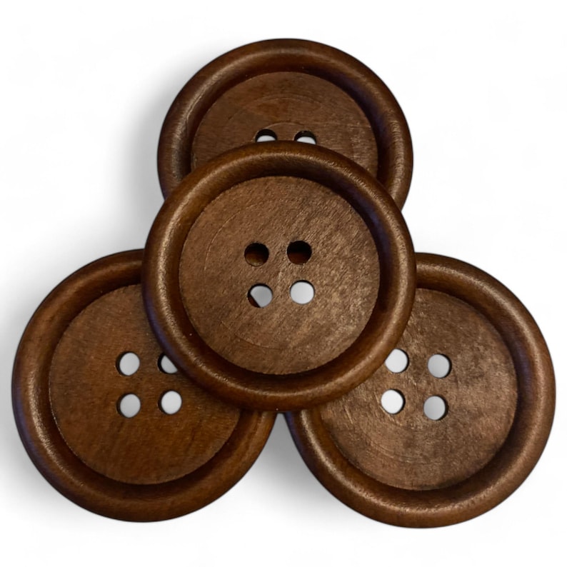 May include: Four brown wooden buttons with four holes each. The buttons are arranged in a triangular shape.