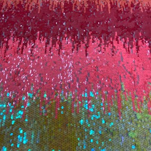 May include: A fabric with a gradient of sequins in shades of red, orange, yellow, and green. The sequins are arranged in a vertical pattern, creating a shimmering effect.