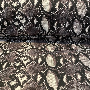 May include: Black and white snakeskin patterned fabric with a subtle sheen. The fabric is folded in half, showing the pattern on both sides.