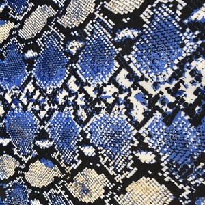 May include: Blue, black and white snake skin patterned fabric. The pattern is a repeating design of snakeskin scales.