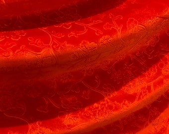 May include: Orange fabric with a floral pattern. The fabric is soft and velvety.