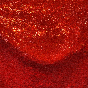 May include: Red sequin fabric with a shimmery, sparkly texture. The sequins are closely packed together, creating a smooth and luxurious surface.