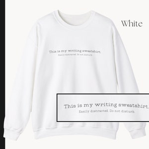 K&ouml;nnte beinhalten: Wei&szlig;er Pullover mit dem Text "This is my writing sweatshirt. Easily distracted. Do not disturb."