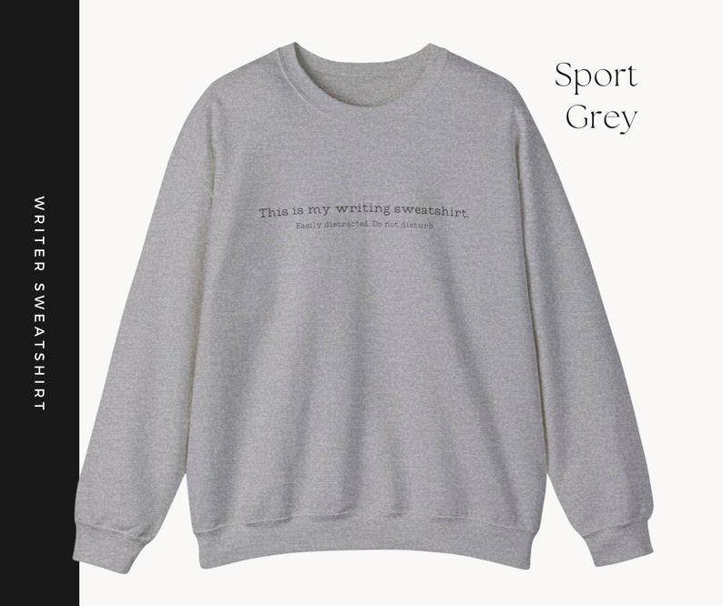 K&ouml;nnte beinhalten: Ein grauer Sweatshirt mit dem Text "This is my writing sweatshirt. Easily distracted. Do not disturb." auf der Vorderseite.