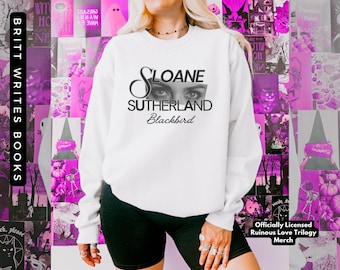 Puede incluir: Sudadera blanca con texto negro que dice "Sloane Sutherland Blackbird". El texto está superpuesto con un par de ojos. La sudadera es mercancía oficial con licencia de la "Ruinous Love Trilogy".