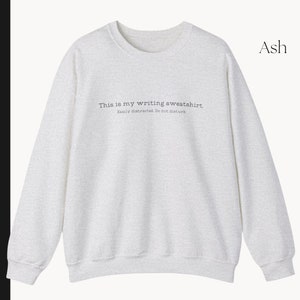K&ouml;nnte beinhalten: Ein hellgraues Sweatshirt mit dem Text "This is my writing sweatshirt. Easily distracted. Do not disturb" auf der Vorderseite. Das Sweatshirt ist aus weichem, bequemem Material gefertigt und hat eine lockere Passform.