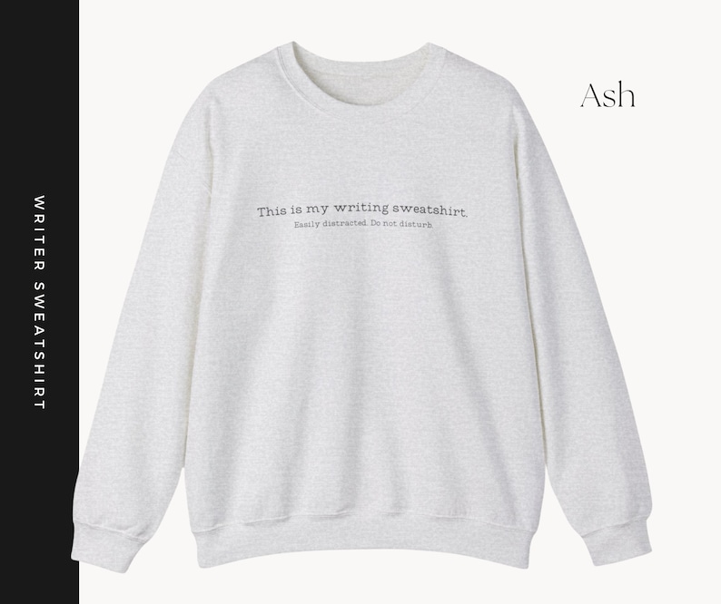 K&ouml;nnte beinhalten: Ein hellgraues Sweatshirt mit dem Text "This is my writing sweatshirt. Easily distracted. Do not disturb" auf der Vorderseite. Das Sweatshirt ist aus weichem, bequemem Material gefertigt und hat eine lockere Passform.